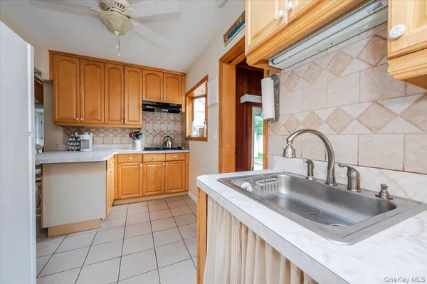 a kitchen with granite countertop a sink a stove and cabinets