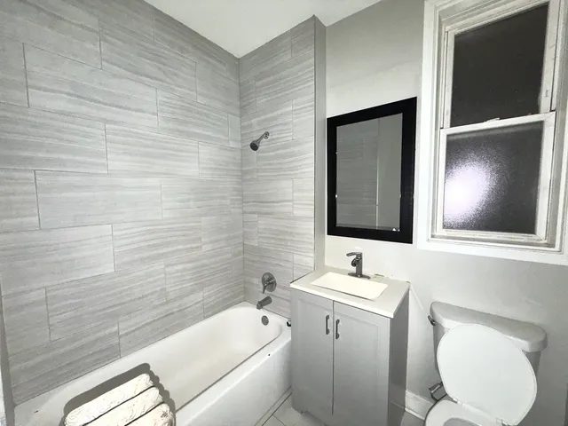 a bathroom with a toilet a sink a mirror and bathtub