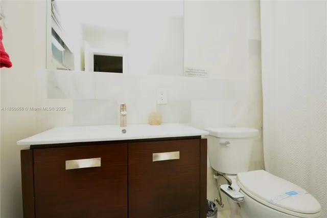a bathroom with a sink a toilet a mirror and shower