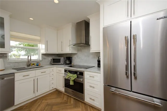 a kitchen with a refrigerator a sink and cabinets