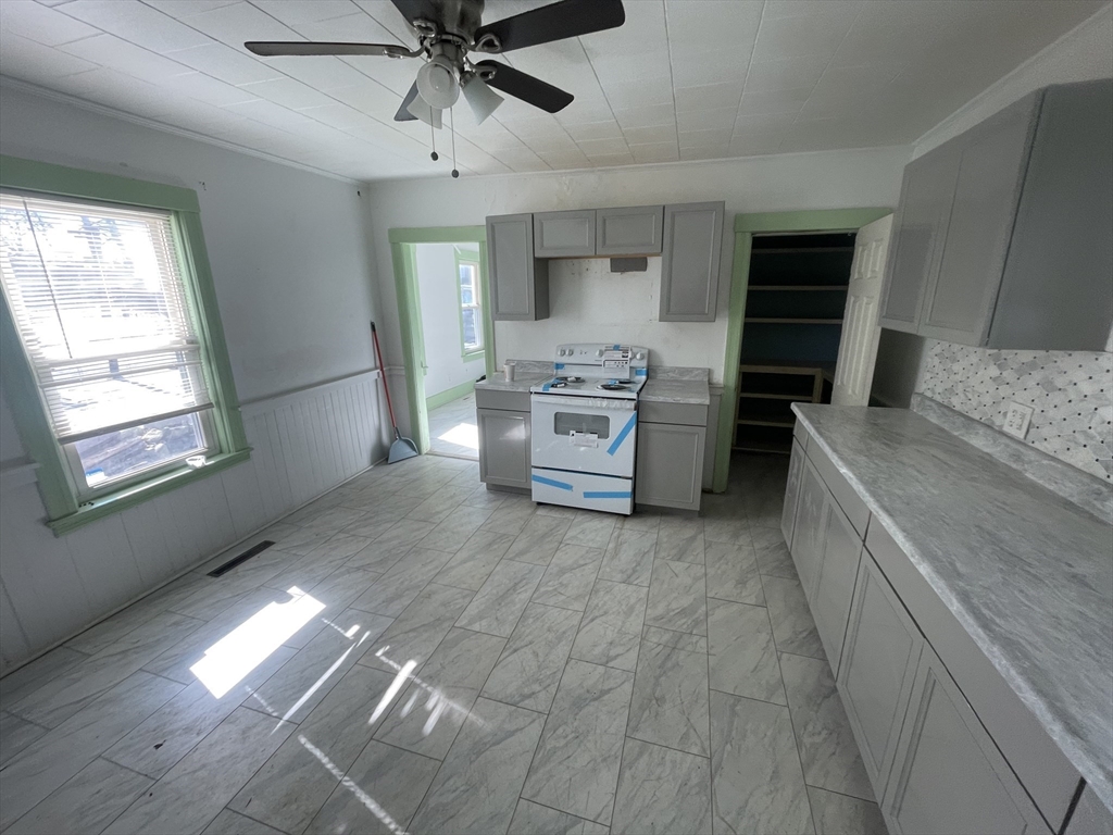 3 Ely Street Worcester, MA 01610 - Photo 4 of 17 a kitchen with stainless steel appliances kitchen island granite countertop a stove a refrigerator and a fireplace
