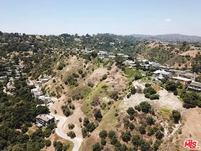 an aerial view of house with yard and mountain view in back