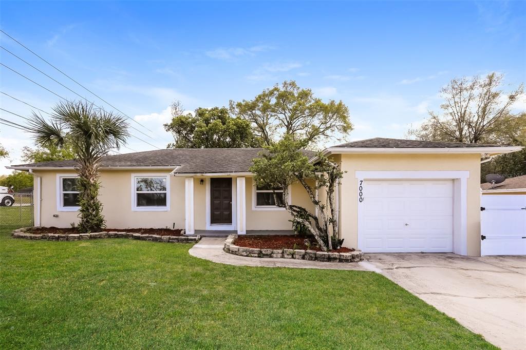 a front view of house with yard and trees in the background