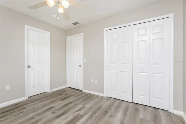 a view of an empty room with chandelier fan