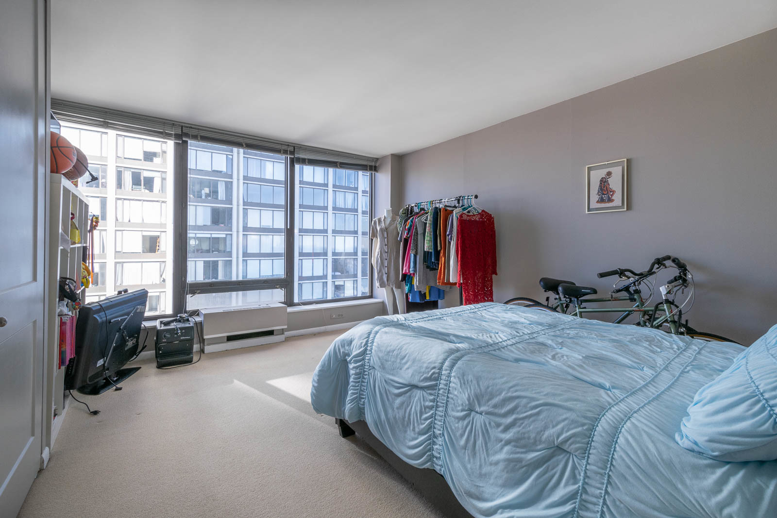 5445 North Sheridan Road, Unit 1701 Chicago, IL 60640 - Photo 9 of 11 a bed sitting in a spacious bedroom next to a window