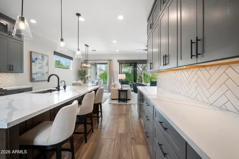 a large white kitchen with a large window and stainless steel appliances
