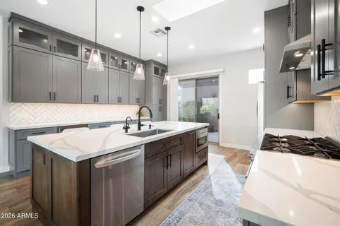 a kitchen with stainless steel appliances granite countertop a sink stove and refrigerator