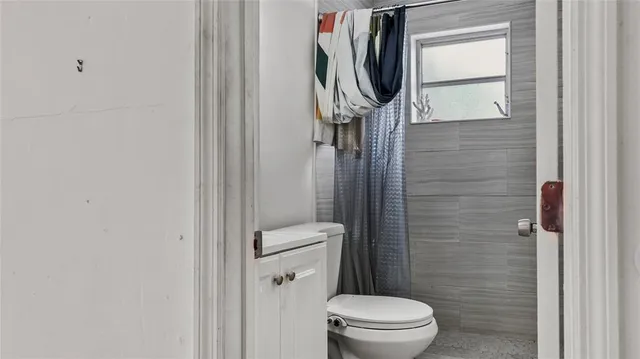 a bathroom with a toilet and a shower