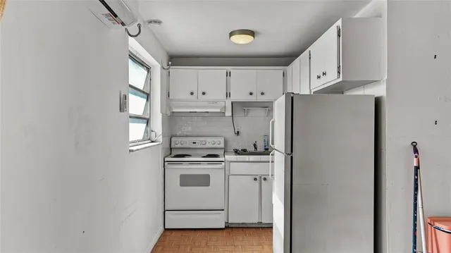 a kitchen with white cabinets and white appliances