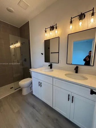 a bathroom with a double vanity sink mirror and toilet