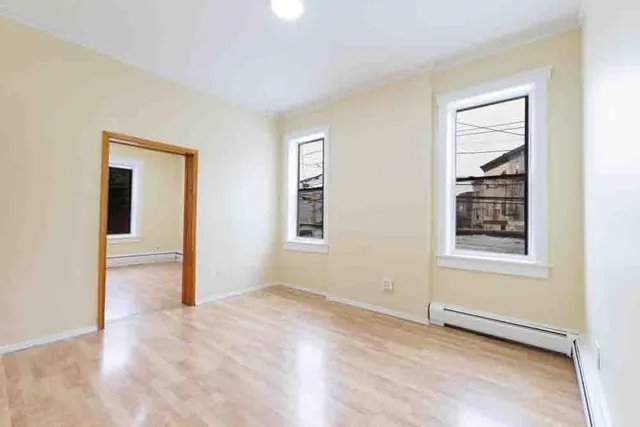 a view of an empty room with window and closet area