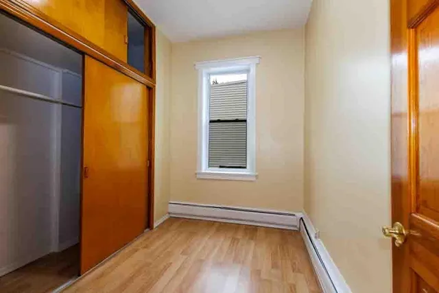 a view of a small space with wooden floor and a window