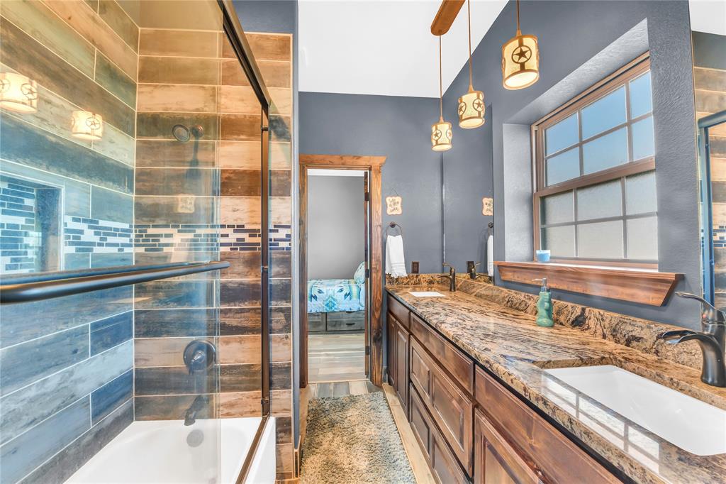 854 County Road 3330 Bridgeport, TX 76426 - Photo 19 of 40 Jack and Jill Bathroom featuring enclosed tub / shower combo, granite countertops, double sinks and custom tile work