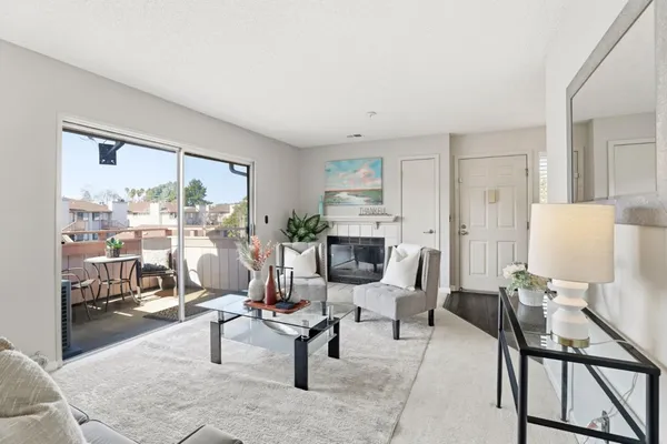 a living room with furniture a rug and a floor to ceiling window