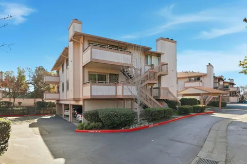 a front view of a house with a garden and parking