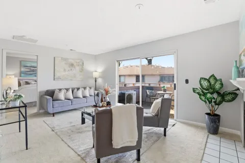 a living room with furniture and a potted plant