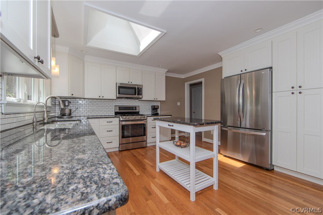 7706 Comanche Drive Richmond, VA 23225 - Photo 12 of 42 a kitchen with granite countertop a refrigerator stove top oven and sink