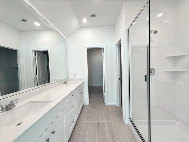 a spacious bathroom with a double vanity sink and a mirror