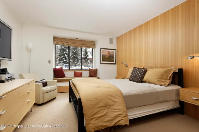 a bedroom with a bed and a large window