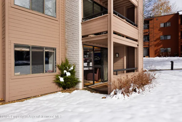 a view of a house with potted plants and covered with wooden fence