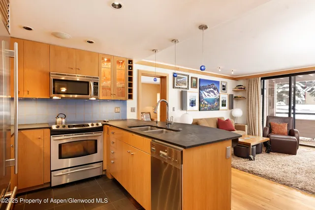 a kitchen with stainless steel appliances granite countertop a stove a sink and a microwave