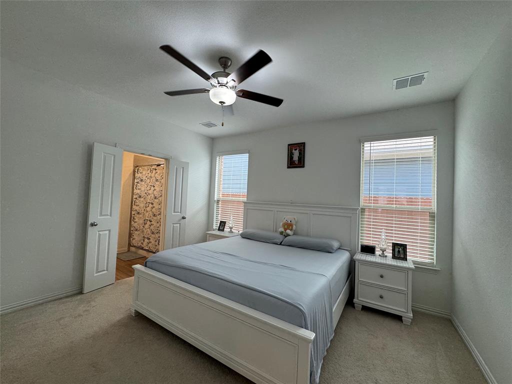3159 Blossom Trail Crandall, TX 75114 - Photo 12 of 25 a spacious bedroom with a bed and a chandelier