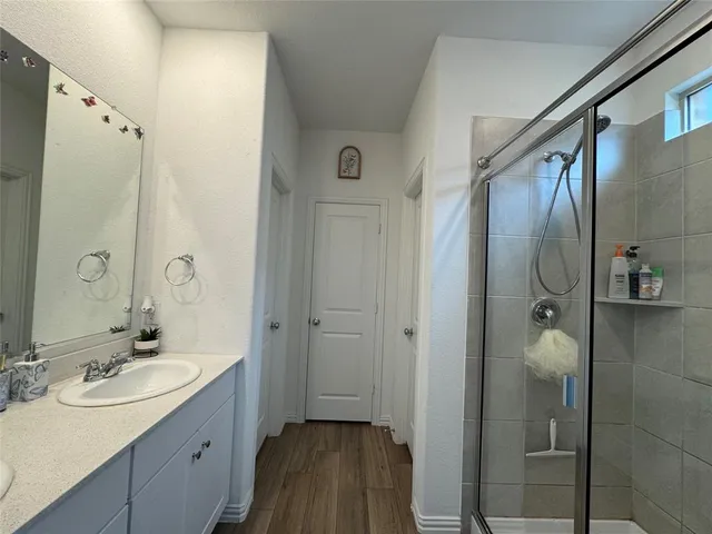 a bathroom with a shower sink and mirror