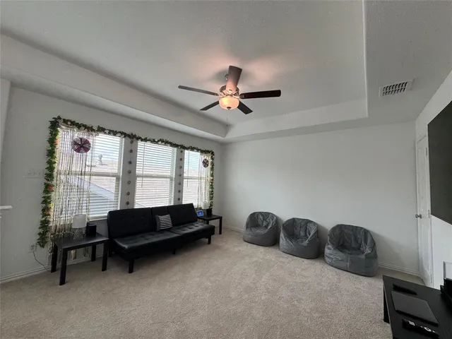 a living room with furniture a ceiling fan and a window