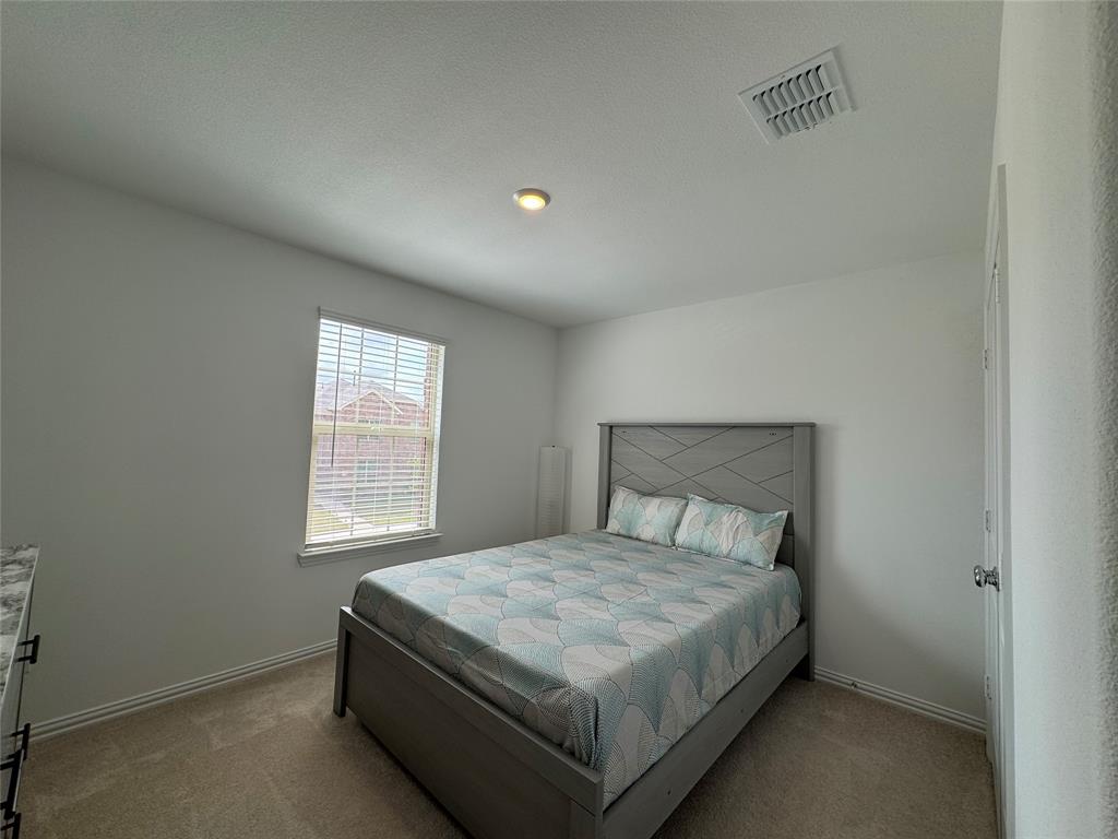 3159 Blossom Trail Crandall, TX 75114 - Photo 19 of 25 a bedroom with a bed and a window