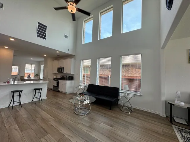 a living room with furniture a flat screen tv and a wooden floor