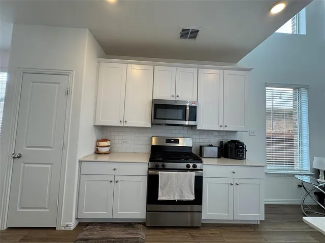 a kitchen with white cabinets and white appliances