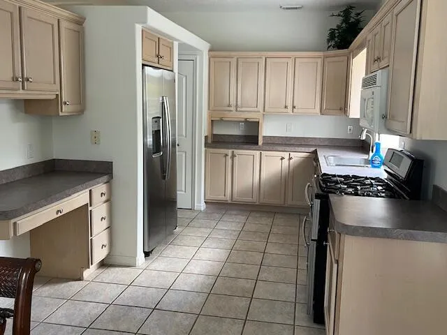 a kitchen with appliances a sink and cabinets