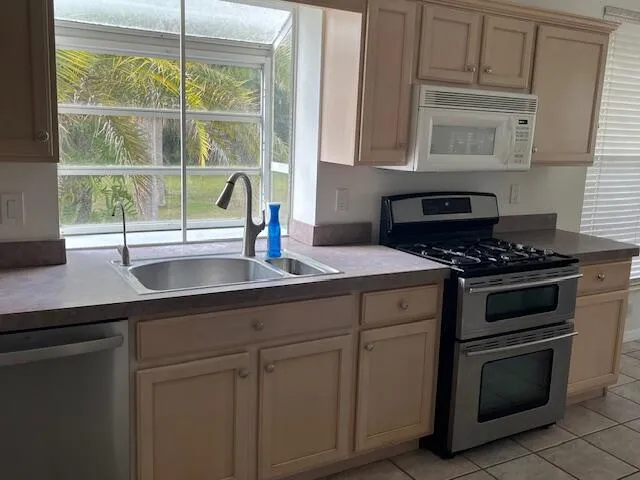 a kitchen with granite countertop a refrigerator and cabinets