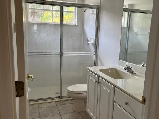 a bathroom with a granite countertop sink toilet and mirror