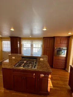 a kitchen with granite countertop a stove and cabinets