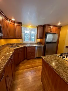 a kitchen with stainless steel appliances granite countertop a sink stove and refrigerator