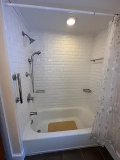 a bathroom with a tub a sink and a shower