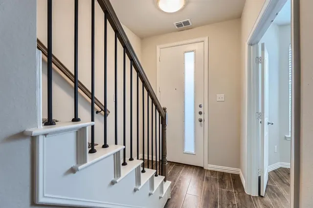 a view of an entryway with wooden floor and staircase