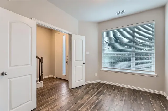 an empty room with wooden floor and a window
