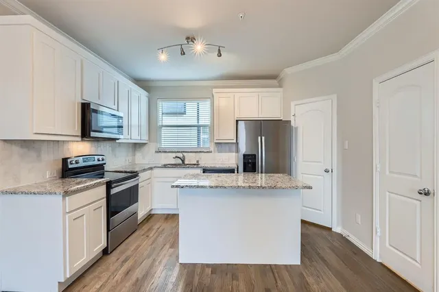 a large kitchen with sink and refrigerator