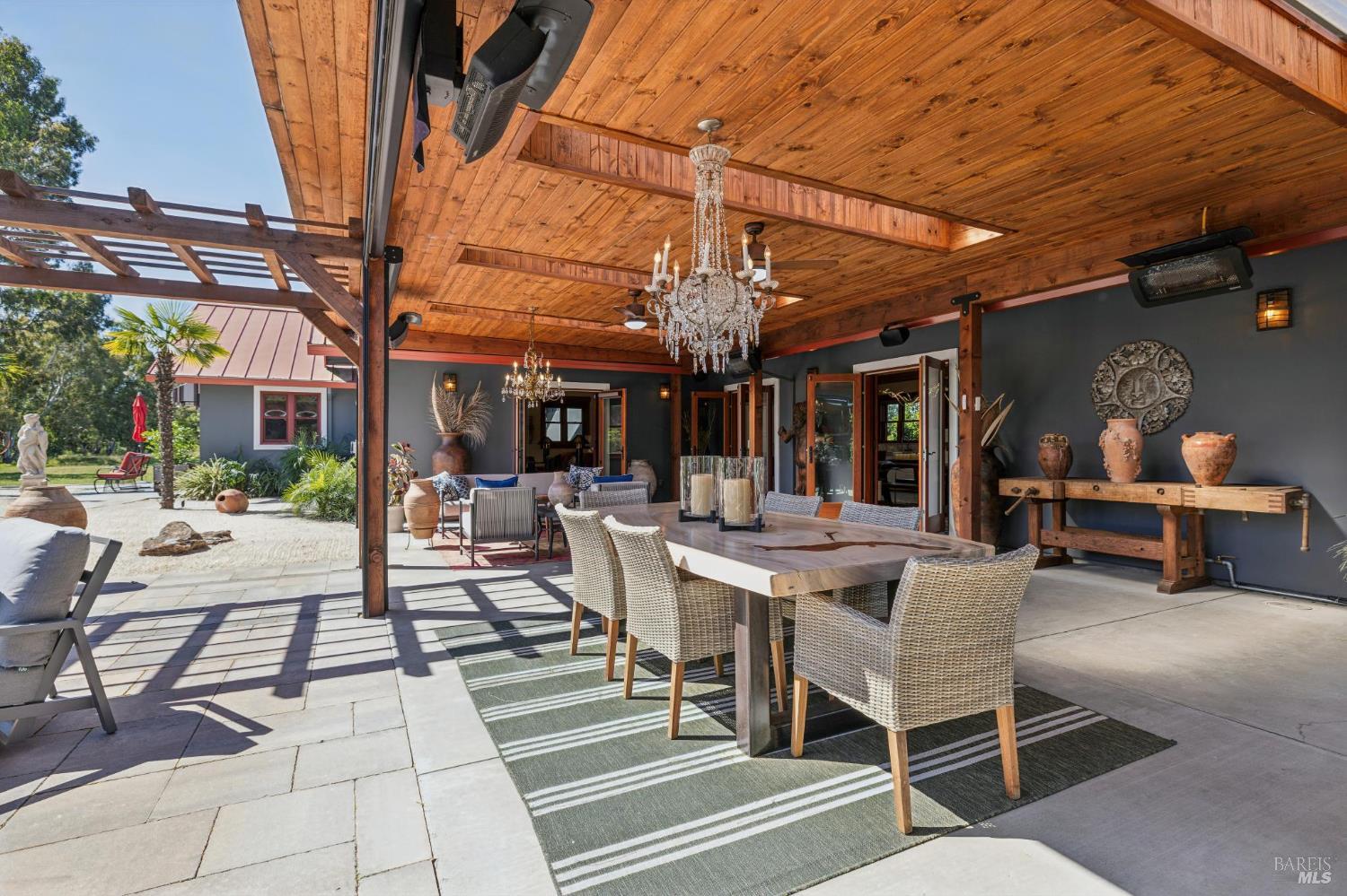 21117 Burndale Road Sonoma, CA 95476 - Photo 12 of 48 a view of a patio with dining table and chairs under an umbrella with a barbeque grill