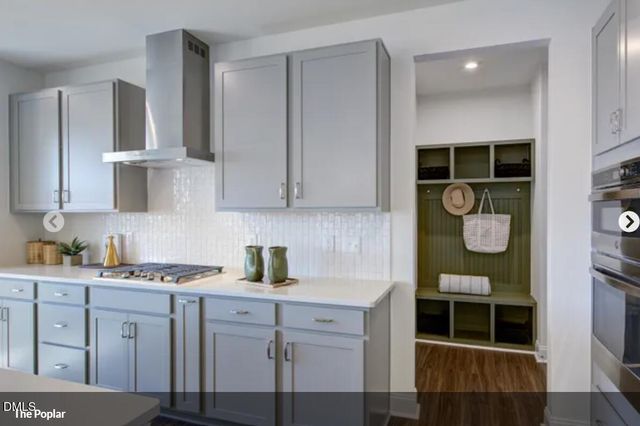 a kitchen with stainless steel appliances white cabinets and a stove top oven