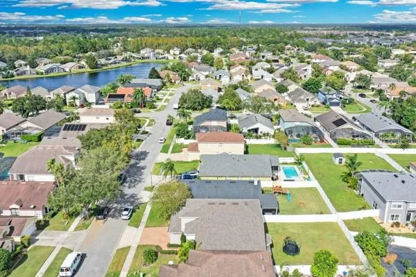 an aerial view of residential houses with outdoor space and ocean view