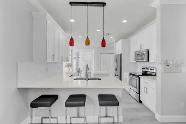 a kitchen with cabinets and chairs