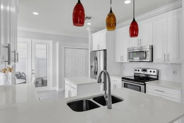 a kitchen with stainless steel appliances granite countertop a sink a stove and a wooden floors