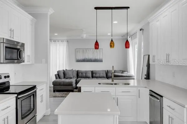 a kitchen with stainless steel appliances granite countertop a sink a stove and a refrigerator