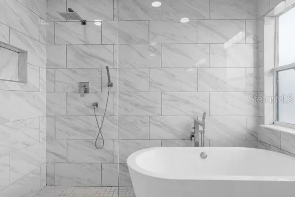a white bath tub sitting in a bathroom and shower