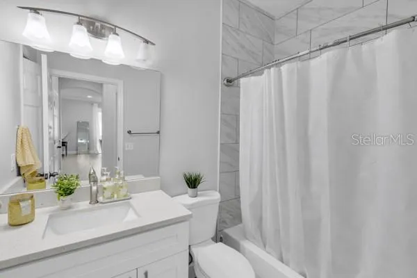 a bathroom with a sink a mirror and a shower curtain