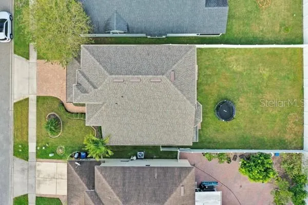 an aerial view of a house with a garden and a car parked