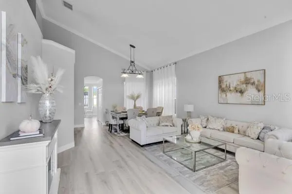a living room with furniture and a chandelier